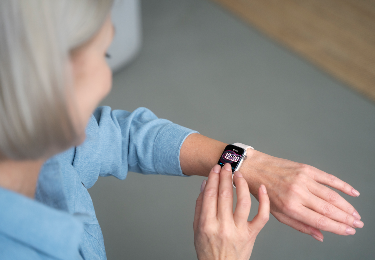 An elderly woman is checking her Apple Watch