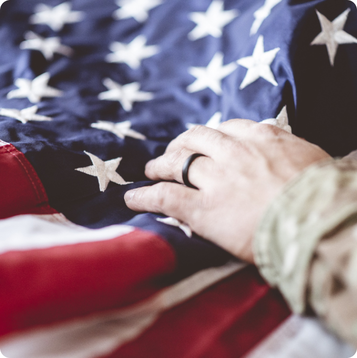 A military veteran placing hand on the American flag.