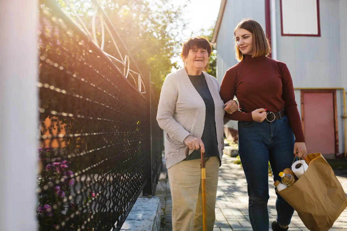 Woman caring for an elderly mother at home, helping with grocery shopping