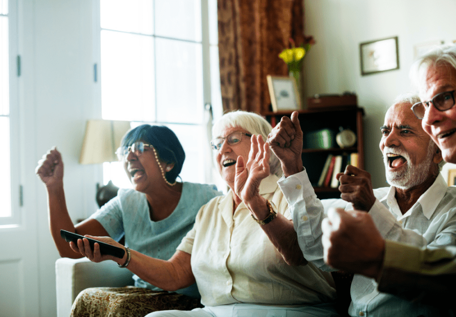 Elderly people celebrating in front of the TV