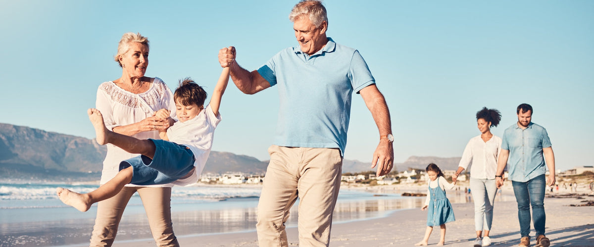 family enjoying vacation traveling with elderly parents on the beach