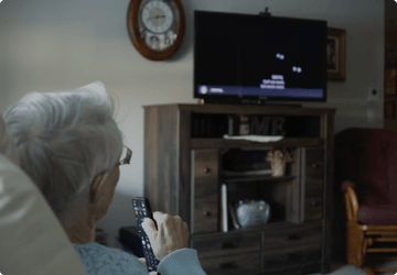 elderly woman using simple voice remote for seniors