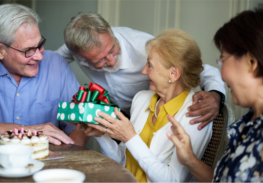 elderly woman receiving a holiday gift from her family