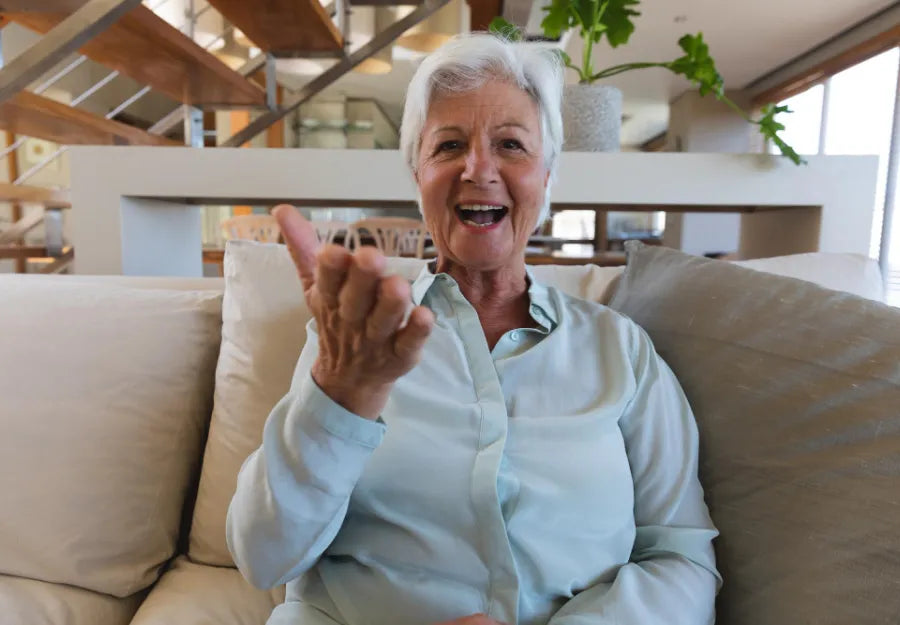 elderly woman on a video call waving