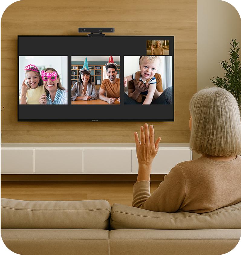 Woman on a video call with several people on a large TV screen in a living. room.