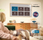 Elderly person sitting on a couch in a living room with a smart TV displaying various app icons.