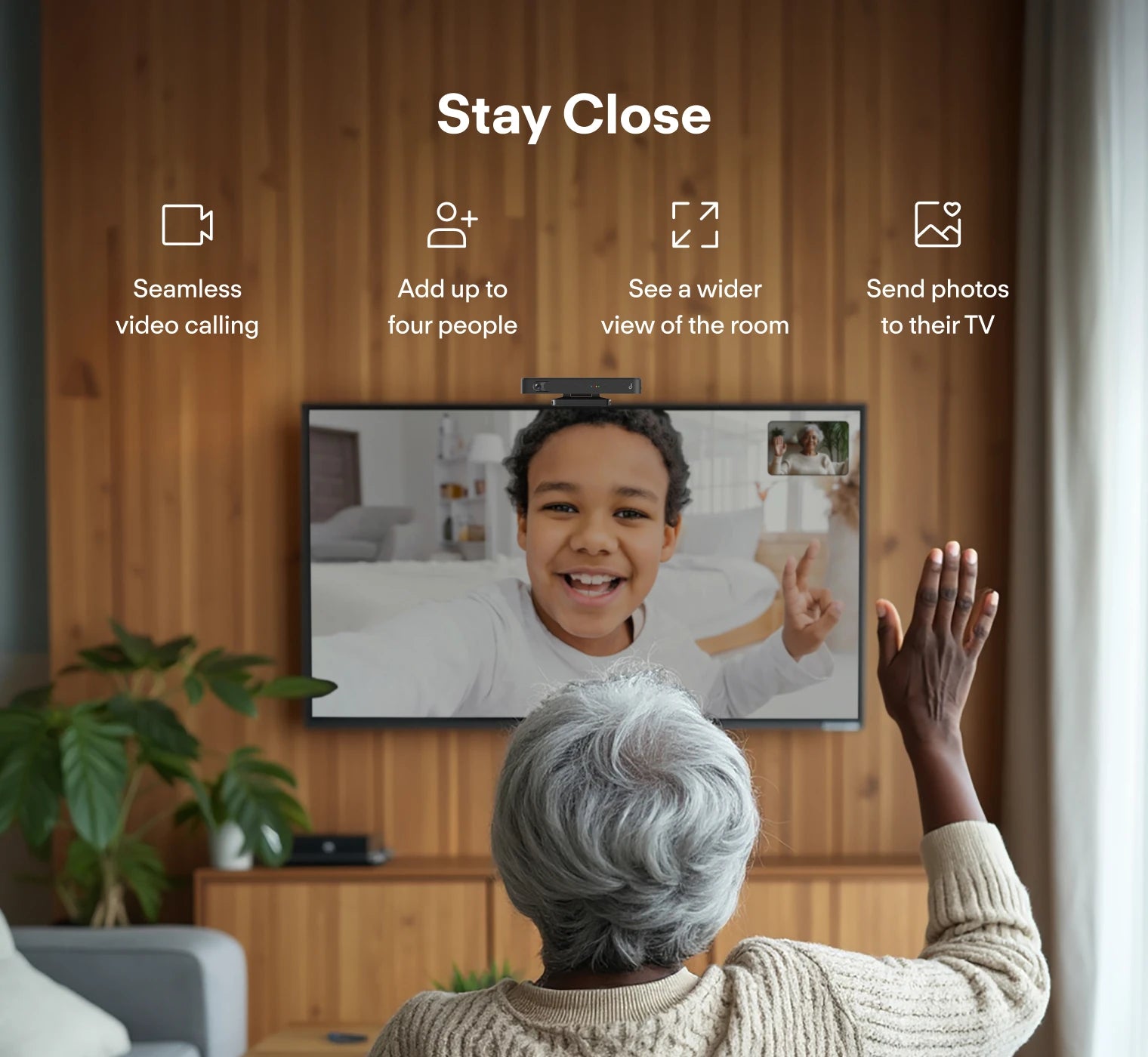 Elderly person using a video call feature on a television with a wooden wall background