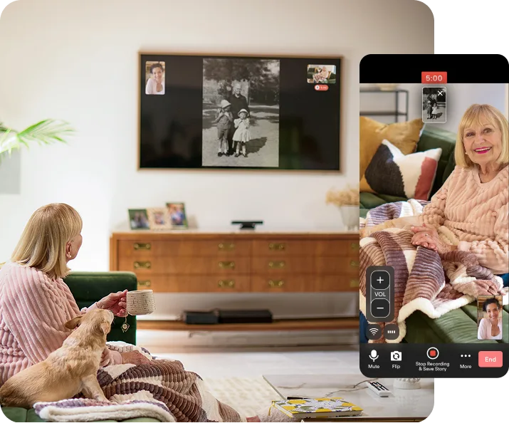 Elderly woman sitting on a couch with a dog telling her daughter a story about the photo on the television.