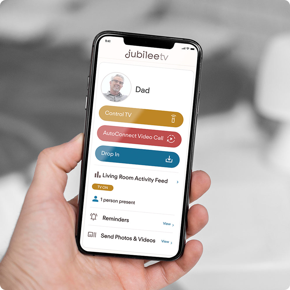 holding a phone showing jubileeTV app homescreen
