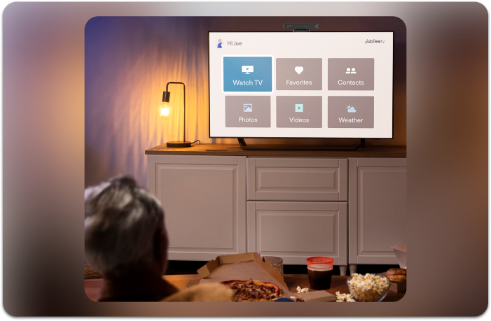 elderly man watching tv with simple jubileetv menu on his screen