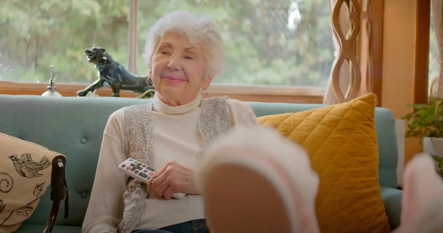 elderly woman holding voice remote for seniors
