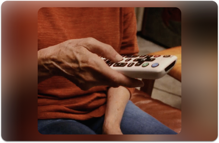 elderly woman holding simple universal remote for seniors